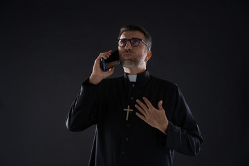 Priest talking smartphone funny expression