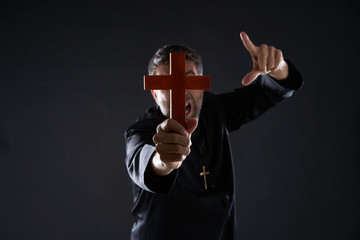 Priest holding cross of wood praying