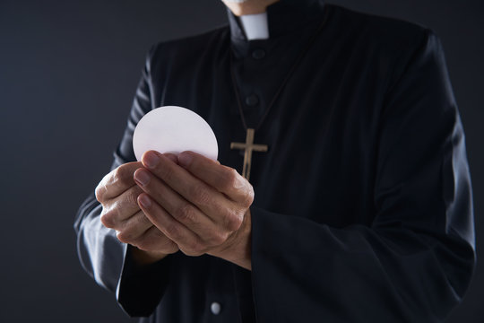 Communion wafer hostia priest in hands