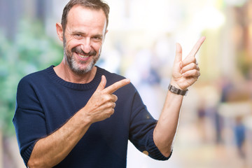 Middle age hoary senior man over isolated background smiling and looking at the camera pointing with two hands and fingers to the side.