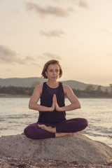 Fototapeta na wymiar Woman practicing yoga on the beach at sunset.