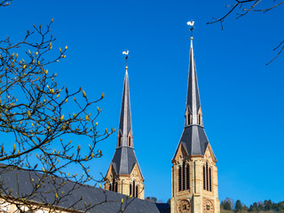 The two church spires of the Parish Church of St. Lawrence in Diekirch, Luxembourg topped by...