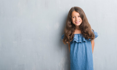 Fototapeta premium Young hispanic kid over grunge grey wall with a happy and cool smile on face. Lucky person.