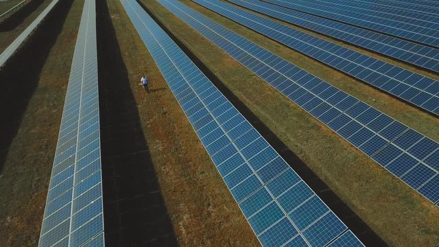 Man walking at solar energy station. Shot on drone