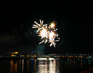 Fototapeta premium Salute of blue yellow white green fire splashes against the night Kostroma