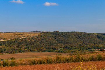 Obraz premium Picturesque autumn scenery with blue sky and colorful autumn trees on mountain hills