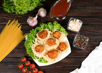 Meat balls in tomato sauce Tagliatelle and basil on a wooden background