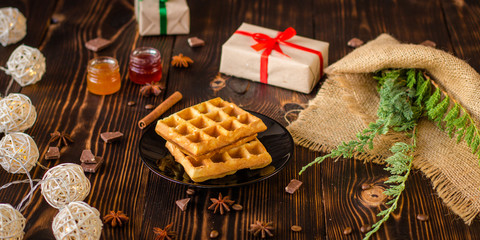 fresh belgian Tasty waffles and gifts on a wooden background. top view.