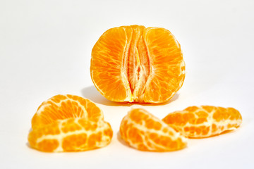 A peeled tangerine photographed in studio isolated in macro with a white background