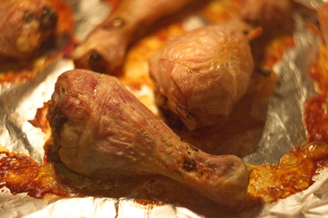 Abstract composition for designers with hot grilled fowl leg dish on foil in oil