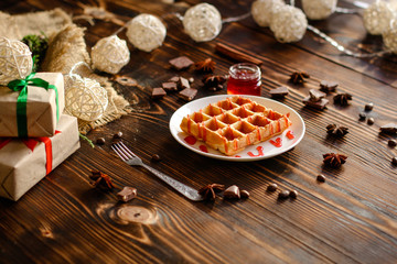 fresh belgian Tasty waffles and gifts on a wooden background. top view.