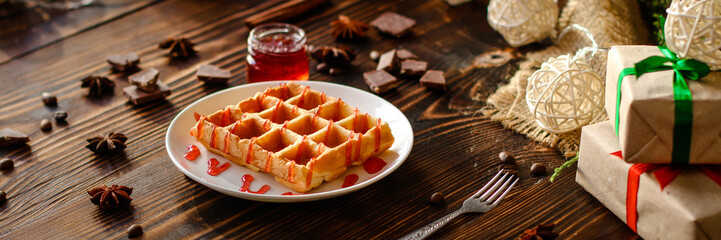 fresh belgian Tasty waffles and gifts on a wooden background. top view.