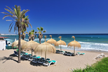 Beach in the popular resort of Marbella in Spain, Costa del Sol, Andalucia region, Malaga province. - obrazy, fototapety, plakaty