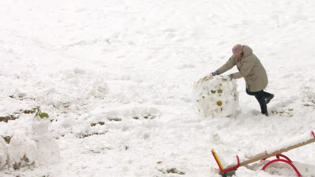 woman roll a snowball
