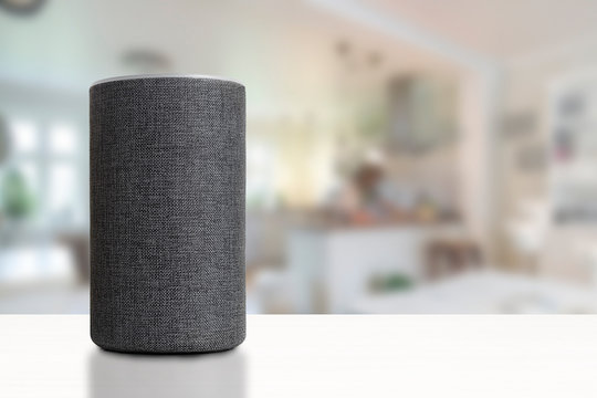Personal assistant loudspeaker on a white wooden shelf of a smart home kitchen. Empty copy space for Editor's text.