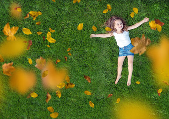 Relaxed little girl lying on a fresh, green lawn