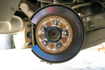 Closeup detail of the wheel assembly on a modern automobile. The rim is removed showing the front rotor and caliper.