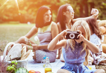 Cheerful mothers and their daughters on a picnic