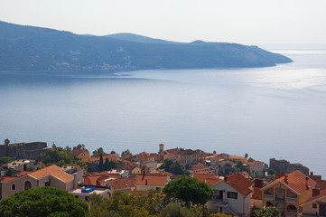 Fototapeta premium Beautiful Mediterranean landscape. Montenegro, Adriatic Sea. View of Bay of Kotor, Lustica peninsula and red roofs of seaside town of Herceg Novi