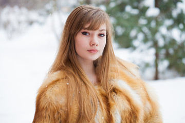 Beautiful elegant brunette woman wearing fur coat