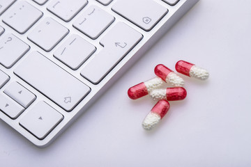 A bunch of pills next to the computer