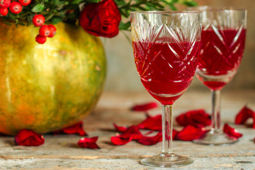 red wine in a glass and flowers on a wooden background. top view.