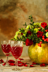 red wine in a glass and flowers on a wooden background. top view.