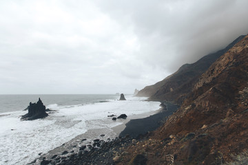 beautiful dramatic view to the Benijo beach with rocks in the ocean in the cloudy evening Tenerife, Spain