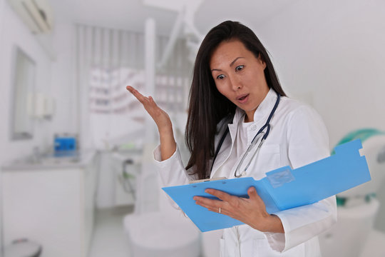 Asian woman doctor looking at bad medical results