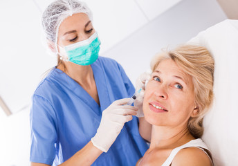 Woman during beauty facial injections