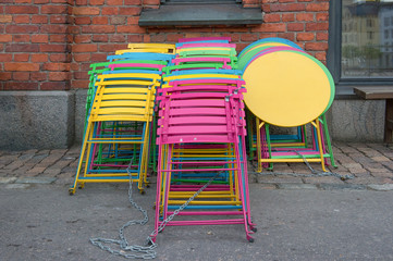 Fototapeta na wymiar stacked bright and colorful metal chairs and tables