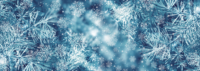 Christmas background with fir branches, glow, snowflakes and bokeh.