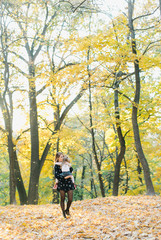 Obraz premium young mother with daughter are walking in the park in the golden autumn