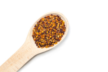 Bee pollen in the wooden spoon on white background