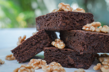 Brownies caseros de chocolate con nueces enteras servidos en un plato blanco