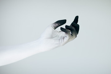 Creepy Halloween monster hand with white and black make up in front of white background
