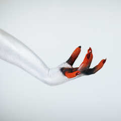 Creepy Halloween monster witch hand with white, red and black make up and long creepy fingernails...