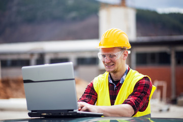 Young industrial worker using lap top