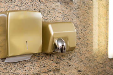 Paper Dispenser and hand dryer on the wall in public toilet