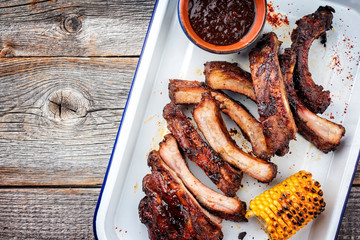 Barbecue spare ribs St Louis cut with hot honey chili marinade as top view in a skillet with copy space left