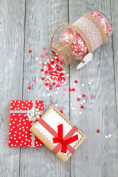 Christmas gifts with colorful hearts on wooden background