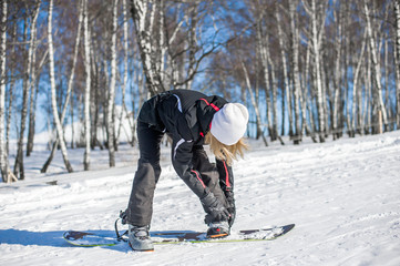 Young adult woman snowboarder standing on board