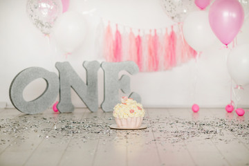 First birthday pink cake with flowers for little baby girl and decorations for cake smash. Big...