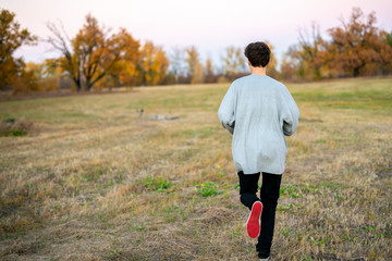 young man run in the field in national park f