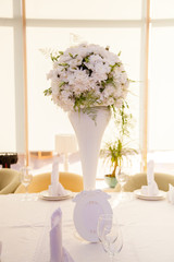 Wedding decor. Bouquet of white flowers on gold background in restaurant