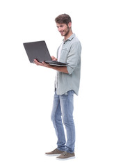 in full growth.smiling young man with laptop