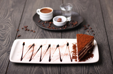 Chocolate cake with cocoa powder with Turkish coffee in the background