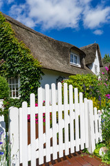 Sehenswürdigkeiten in Nordfriesland - idyllisches Friesenhaus mit weißer Pforte, Bildausschnitt...
