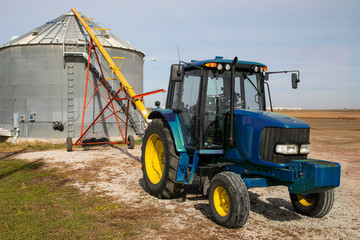 tractor set to auger corn into storage bin