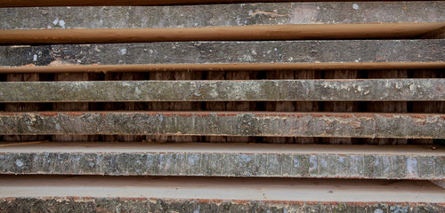 Folded wooden brown and gray planks in a sawmill. Piled alder boards as texture